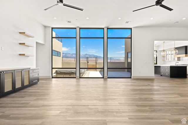4982 W 3175 S, Hurricane, UT 84737 - unfurnished living room with ceiling fan, expansive windows, light wood-type flooring, healthy amount of natural light, and recessed lighting