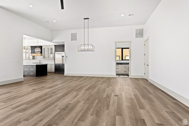 4982 W 3175 S, Hurricane, UT 84737 - unfurnished living room featuring light wood-type flooring, a chandelier, and recessed lighting