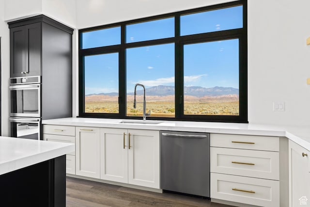 4982 W 3175 S, Hurricane, UT 84737 - kitchen with appliances with stainless steel finishes, light countertops, dark wood-style floors, white cabinetry, and a mountain view
