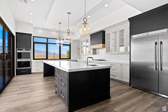4982 W 3175 S, Hurricane, UT 84737 - kitchen with stainless steel appliances, an island with sink, premium range hood, light wood finished floors, and recessed lighting