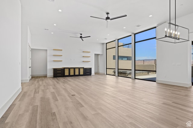 4982 W 3175 S, Hurricane, UT 84737 - unfurnished living room featuring a wall of windows, ceiling fan, light wood finished floors, recessed lighting, and a chandelier