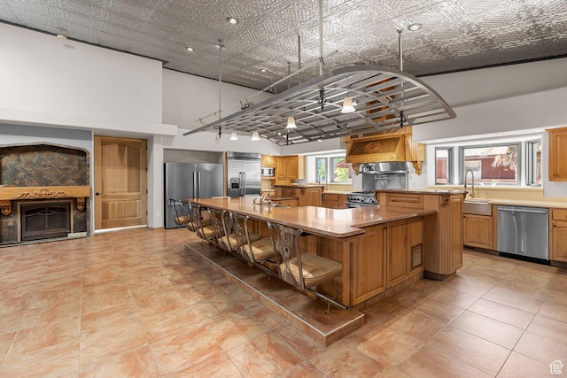 143 E 200 S, St George, UT 84770 - kitchen featuring appliances with stainless steel finishes, a large island with sink, a breakfast bar area, a fireplace, and light countertops