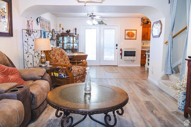 435 W Cobblestone Dr, Providence, UT 84332 - living area featuring arched walkways, a ceiling fan, heating unit, light wood finished floors, and stairway