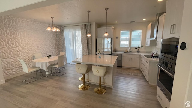 4678 W Vermillion Dr S, South Jordan, UT 84009 - kitchen featuring appliances with stainless steel finishes, white cabinetry, a chandelier, a kitchen island, and light countertops