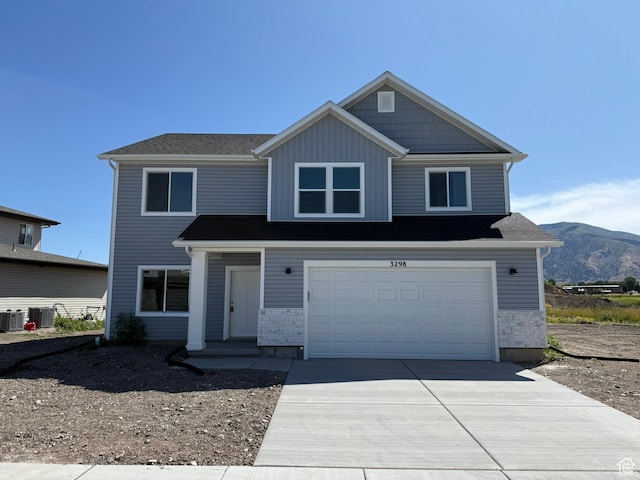 3298 S 1000 W, Nibley, UT 84321 - view of front of property with driveway, a garage, a mountain view, and board and batten siding