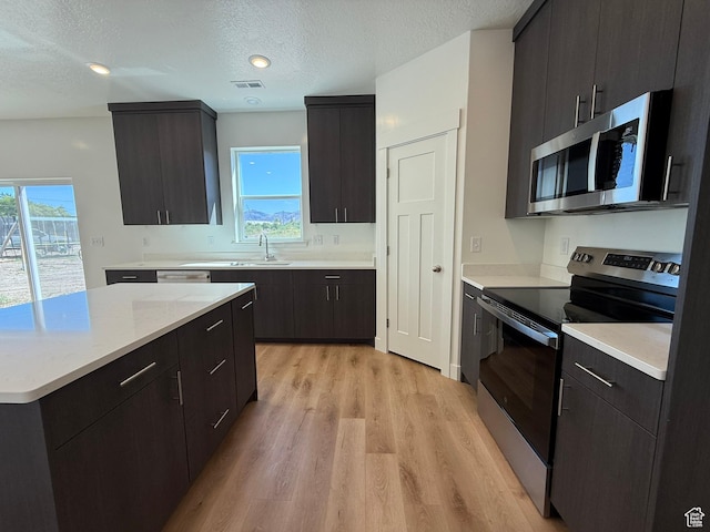 3298 S 1000 W, Nibley, UT 84321 - kitchen with stainless steel appliances, light countertops, a textured ceiling, light wood-type flooring, and modern cabinets