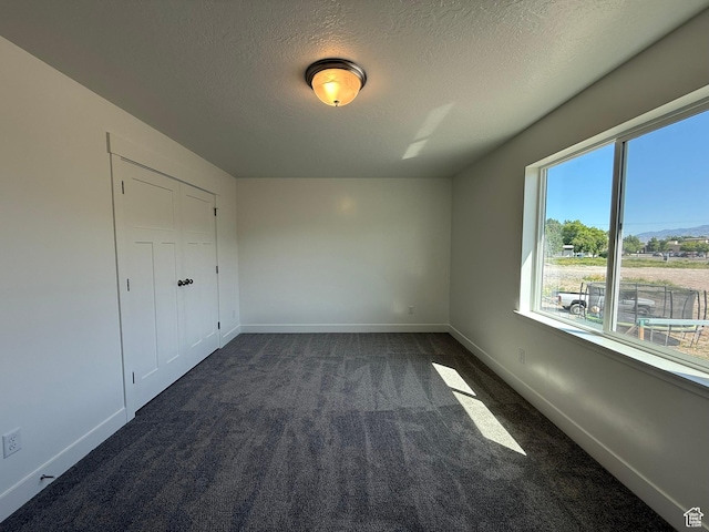 3298 S 1000 W, Nibley, UT 84321 - unfurnished bedroom with a textured ceiling and dark colored carpet