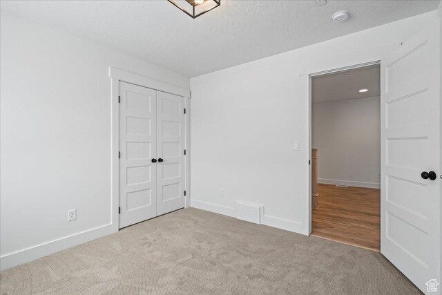 2230 S 635 W Unit C, Perry, UT 84302 - unfurnished bedroom featuring carpet, a closet, and a textured ceiling