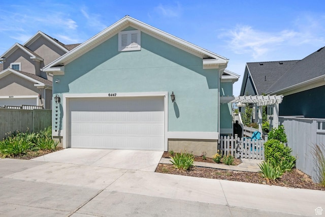 6447 W Arranmore Dr, South Jordan, UT 84009 - view of front facade with an attached garage, a pergola, stucco siding, and driveway