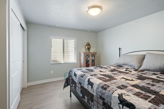 6447 W Arranmore Dr, South Jordan, UT 84009 - bedroom featuring light wood-style flooring, a closet, and a textured ceiling