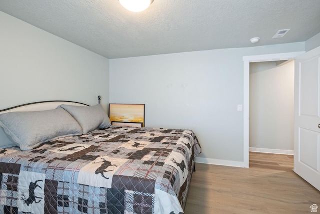 6447 W Arranmore Dr, South Jordan, UT 84009 - bedroom featuring wood finished floors and a textured ceiling