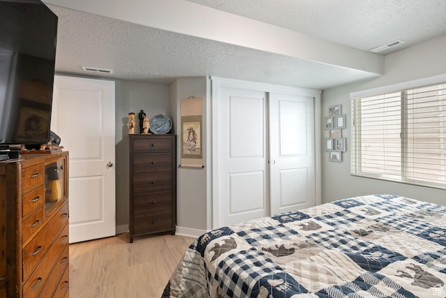 6447 W Arranmore Dr, South Jordan, UT 84009 - bedroom featuring light wood finished floors, a textured ceiling, and a closet