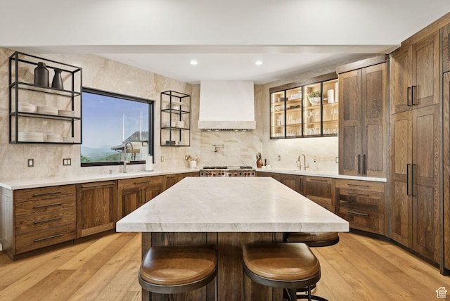 1427 Eagle Way, Park City, UT 84060 - kitchen with custom range hood, backsplash, light countertops, light wood finished floors, and a kitchen island