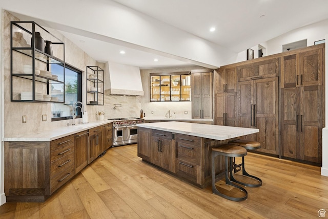 1427 Eagle Way, Park City, UT 84060 - kitchen with double oven range, premium range hood, a kitchen island, light wood finished floors, and decorative backsplash