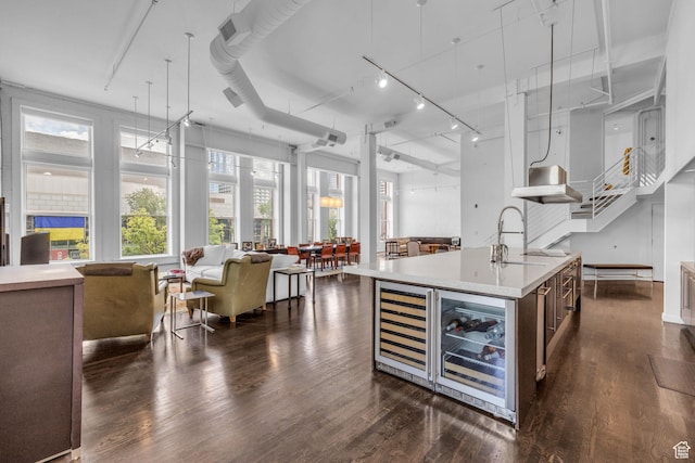 159 W Broadway Unit 301, Salt Lake City, UT 84101 - kitchen featuring wine cooler, open floor plan, light countertops, and an island with sink