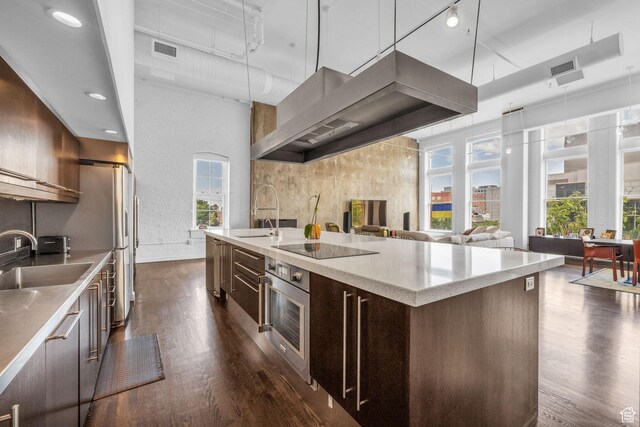 159 W Broadway Unit 301, Salt Lake City, UT 84101 - kitchen featuring oven, dark wood-style floors, modern cabinets, wall chimney exhaust hood, and a high ceiling