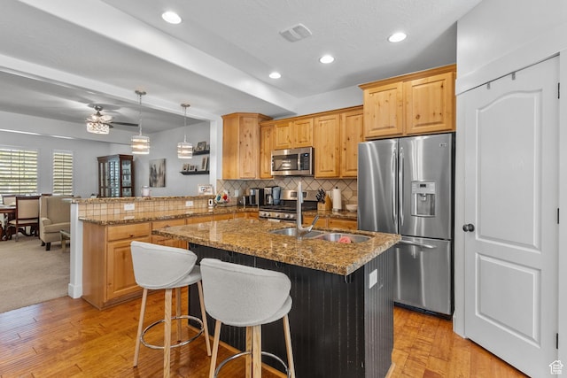 4269 W Lake Brg S, South Jordan, UT 84009 - kitchen with appliances with stainless steel finishes, a peninsula, decorative backsplash, light wood-style floors, and stone counters