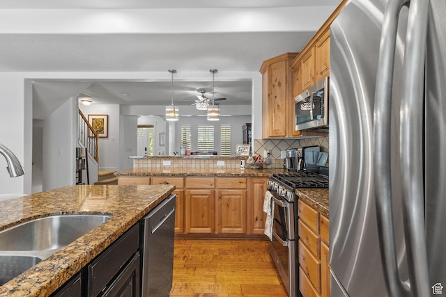 4269 W Lake Brg S, South Jordan, UT 84009 - kitchen featuring stainless steel appliances, light wood-style flooring, decorative backsplash, a ceiling fan, and arched walkways