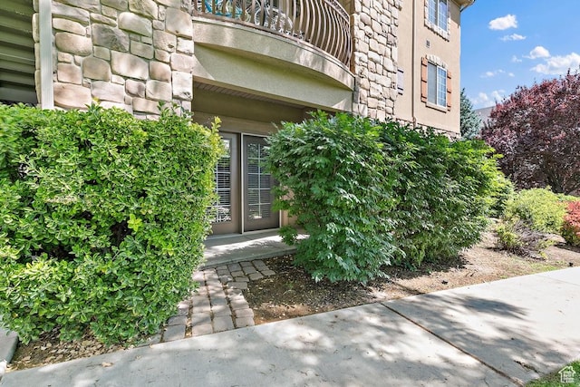 181 N 1200 W Unit 103, Orem, UT 84057 - view of exterior entry with a balcony, stone siding, and stucco siding