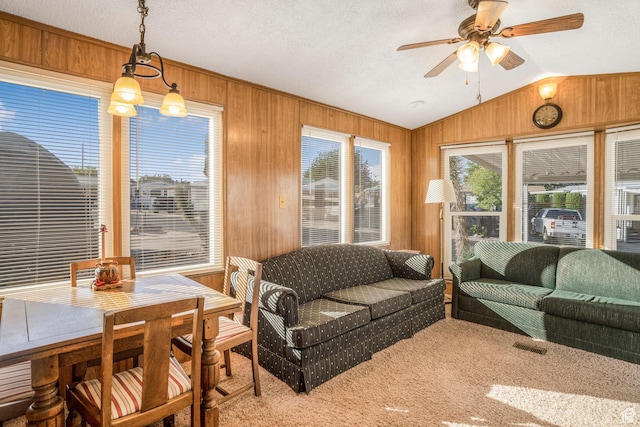 1225 N Dixie Downs Unit 119, St George, UT 84770 - living area with vaulted ceiling, wooden walls, ceiling fan, carpet flooring, and a textured ceiling