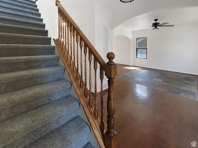 6842 W Grevillea Ln, West Jordan, UT 84081 - stairs with arched walkways, ceiling fan, and stone finish flooring