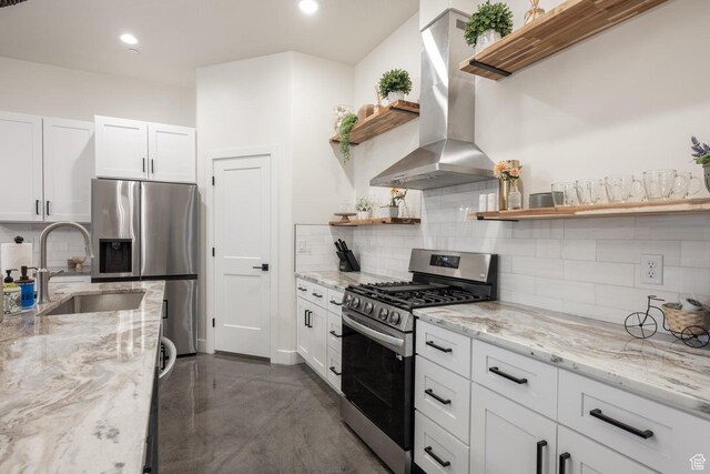 4254 W Cambridge Pkwy, Hurricane, UT 84737 - kitchen featuring open shelves, stainless steel appliances, wall chimney exhaust hood, concrete floors, and tasteful backsplash