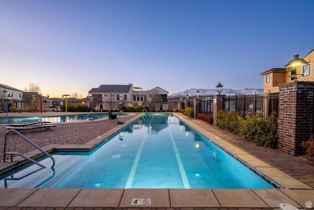 4254 W Cambridge Pkwy, Hurricane, UT 84737 - pool at dusk with a mountain view, a community pool, and a patio