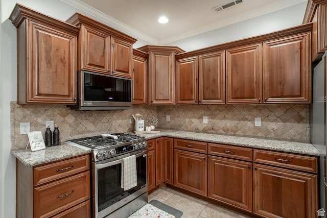 1430 W 365 N, Hurricane, UT 84737 - kitchen with stainless steel appliances, crown molding, light tile patterned flooring, brown cabinets, and light stone countertops