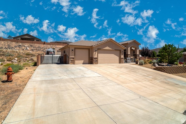 1430 W 365 N, Hurricane, UT 84737 - mediterranean / spanish-style home with a gate, stone siding, a garage, driveway, and stucco siding