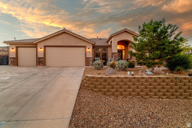 1430 W 365 N, Hurricane, UT 84737 - view of front facade featuring stone siding, stucco siding, a garage, concrete driveway, and a tiled roof