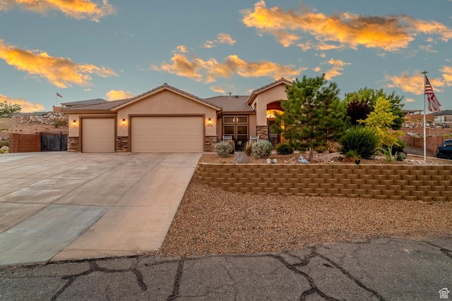 1430 W 365 N, Hurricane, UT 84737 - view of front facade featuring stone siding, a garage, stucco siding, driveway, and a tiled roof