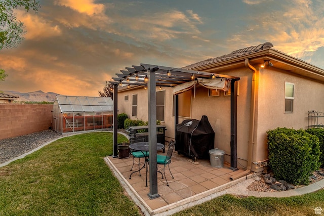 1430 W 365 N, Hurricane, UT 84737 - patio terrace at dusk with a greenhouse, area for grilling, a fenced backyard, an outdoor structure, and a patio area