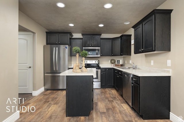 1789 N Aaron Dr E, Tooele, UT 84074 - kitchen featuring appliances with stainless steel finishes, a center island, recessed lighting, dark wood-style flooring, and light countertops