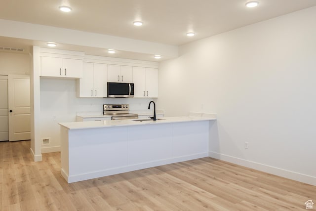 229 W 690 N, Smithfield, UT 84335 - kitchen featuring stainless steel appliances, a peninsula, light wood-style flooring, light countertops, and recessed lighting