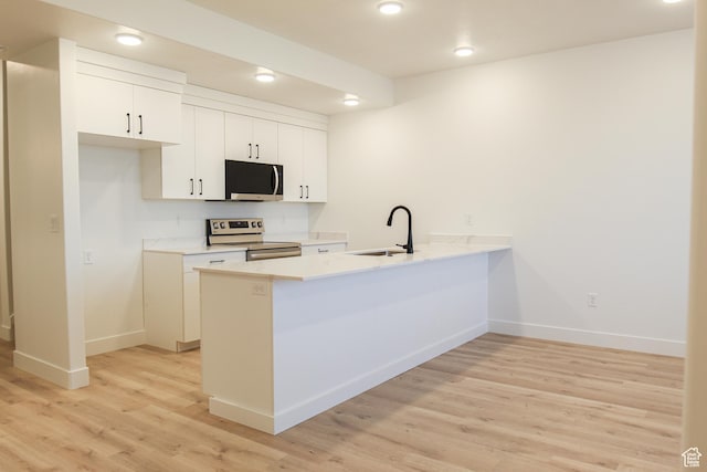 229 W 690 N, Smithfield, UT 84335 - kitchen featuring range with electric stovetop, stainless steel microwave, a peninsula, light wood-style flooring, and white cabinetry