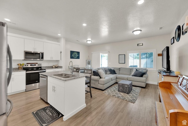 382 E 1850 N Unit 5, North Ogden, UT 84414 - kitchen featuring appliances with stainless steel finishes, light wood-type flooring, open floor plan, a kitchen island with sink, and recessed lighting