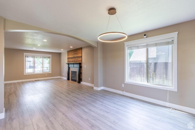 1033 S Southgate Ct W, Logan, UT 84321 - unfurnished living room featuring light wood finished floors, a large fireplace, arched walkways, and recessed lighting