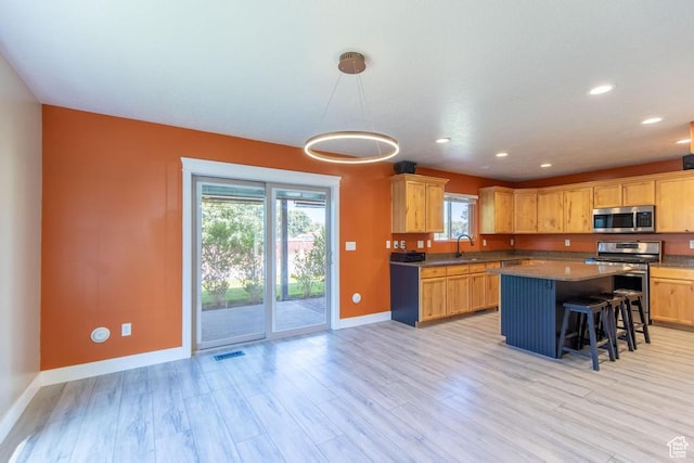 1033 S Southgate Ct W, Logan, UT 84321 - kitchen featuring stainless steel appliances, plenty of natural light, light wood-type flooring, a breakfast bar area, and recessed lighting