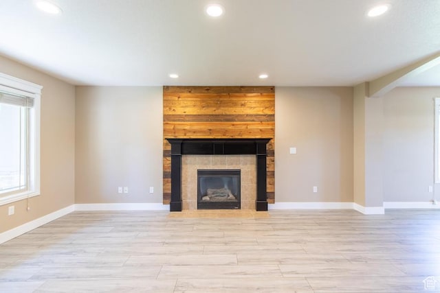 1033 S Southgate Ct W, Logan, UT 84321 - unfurnished living room with recessed lighting, light wood-style flooring, a fireplace, and arched walkways