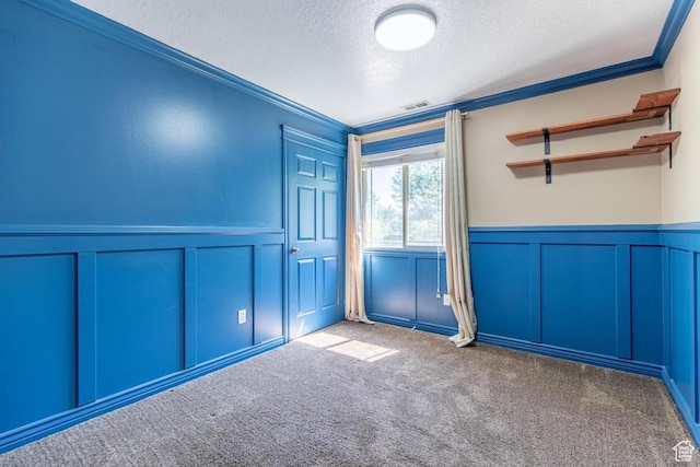 1033 S Southgate Ct W, Logan, UT 84321 - carpeted empty room featuring a decorative wall, a textured ceiling, wainscoting, and ornamental molding