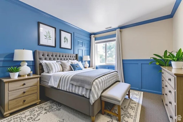 1033 S Southgate Ct W, Logan, UT 84321 - bedroom with a decorative wall, a wainscoted wall, crown molding, and carpet floors