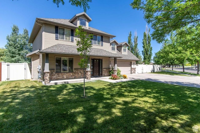 1033 S Southgate Ct W, Logan, UT 84321 - view of front of house with driveway, a gate, covered porch, stone siding, and an attached garage