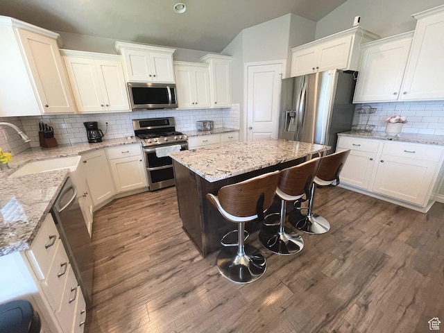 2433 N 1445 W, Clinton, UT 84015 - kitchen with appliances with stainless steel finishes, backsplash, white cabinetry, a center island, and dark wood finished floors