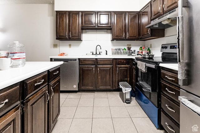 245 N Vine St Unit 205, Salt Lake City, UT 84103 - kitchen featuring stainless steel appliances, under cabinet range hood, light countertops, light tile patterned floors, and dark brown cabinetry