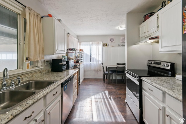 565 W 300 S, Provo, UT 84601 - kitchen with appliances with stainless steel finishes, dark wood-type flooring, a textured ceiling, white cabinetry, and under cabinet range hood