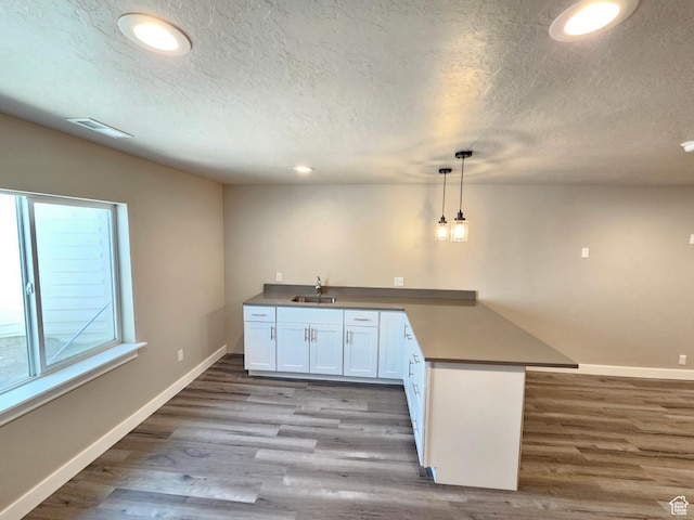 3538 N Willy Way Unit 167, Eagle Mountain, UT 84005 - kitchen featuring a peninsula, wood finished floors, a textured ceiling, recessed lighting, and pendant lighting