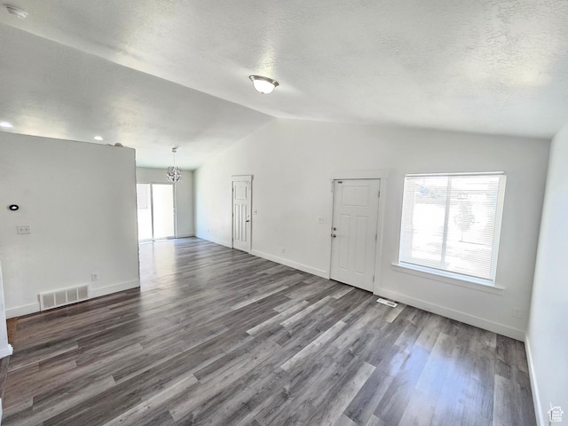 3538 N Willy Way Unit 167, Eagle Mountain, UT 84005 - unfurnished living room featuring lofted ceiling, a chandelier, dark wood-style floors, and a textured ceiling