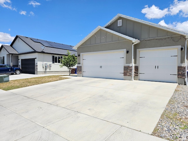 3538 N Willy Way Unit 167, Eagle Mountain, UT 84005 - view of front of home featuring board and batten siding, stone siding, a garage, driveway, and stucco siding