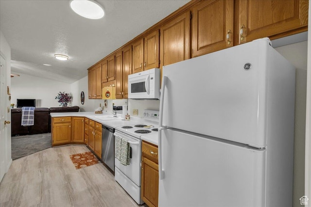 1331 N Dixie Downs Rd Unit 56, St George, UT 84770 - kitchen with white appliances, light wood-style floors, brown cabinets, light countertops, and lofted ceiling