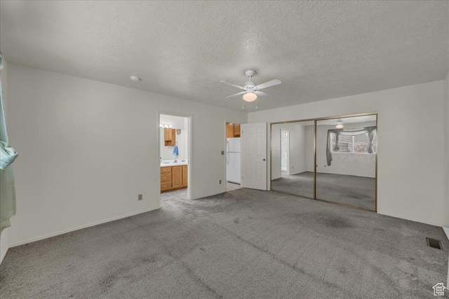 1331 N Dixie Downs Rd Unit 56, St George, UT 84770 - unfurnished bedroom with freestanding refrigerator, carpet flooring, a textured ceiling, a closet, and a ceiling fan